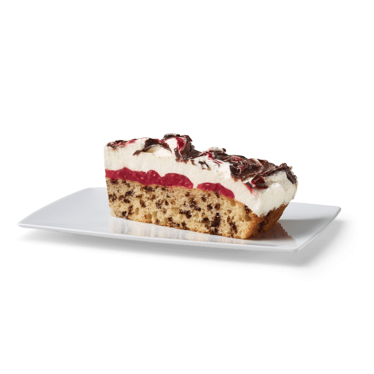 Stück Sahnetorte mit Schokoladenguss und roter Fruchtfüllung auf einem weißen Teller