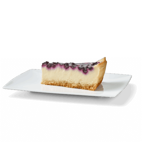 Stück Käsekuchen mit Blaubeerglasur auf einem weißen Teller