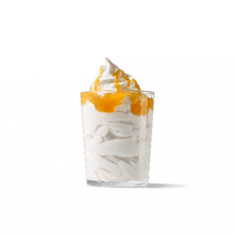 Ein Glas mit cremigem Sahneeis, mit einer Mango-Passionsfrucht-Sauce.