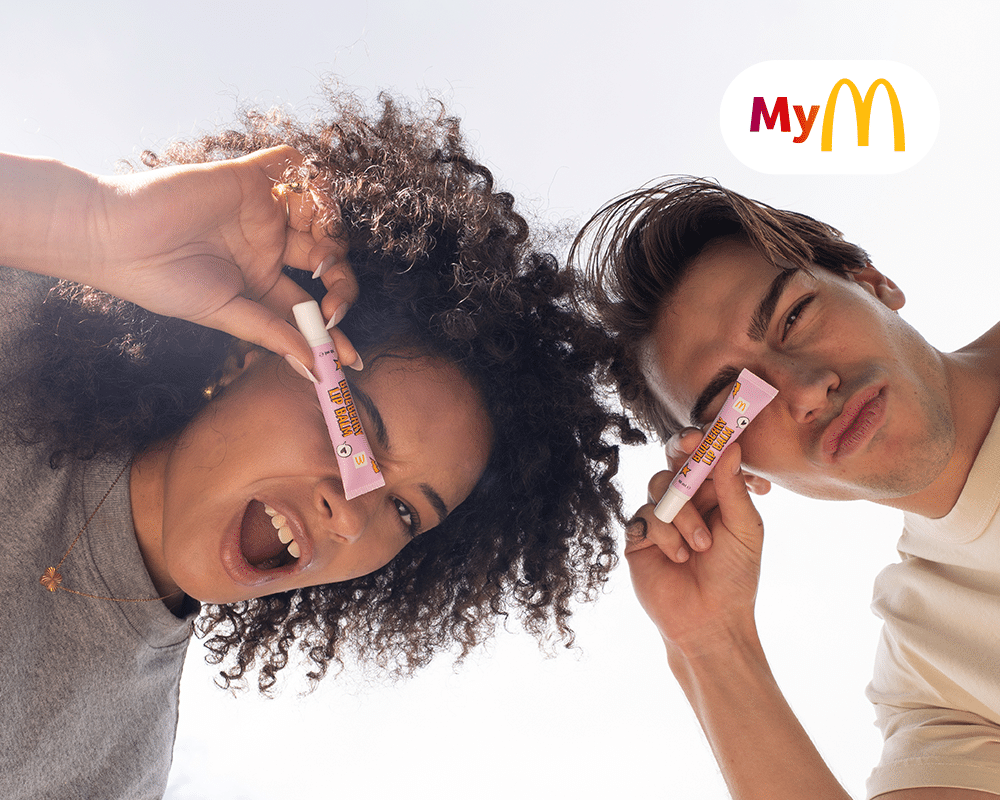 Junge und Mädchen halten eine Lippenpflege in die Kamera, beide wirken fröhlich und dynamisch.