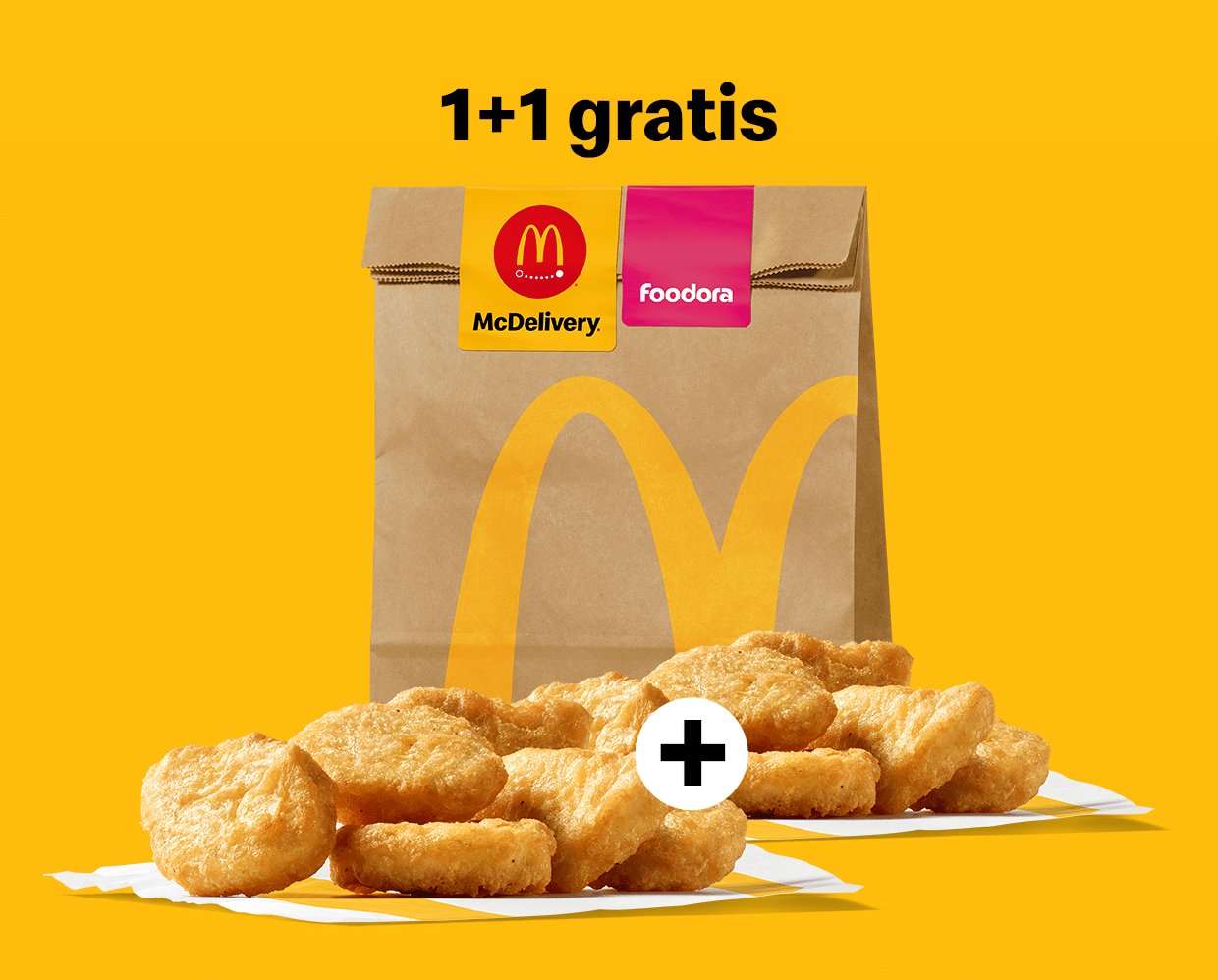 zwei Portionen Chicken McNuggets, die durch ein Plus-Zeichen miteinander verbunden sind, liegen auf einer Fläche vor einem großen Papiersackerl mit McDelivery-Sticker und foodora-Sticker; darüber befindet sich der Schriftzug „1+1 gratis“