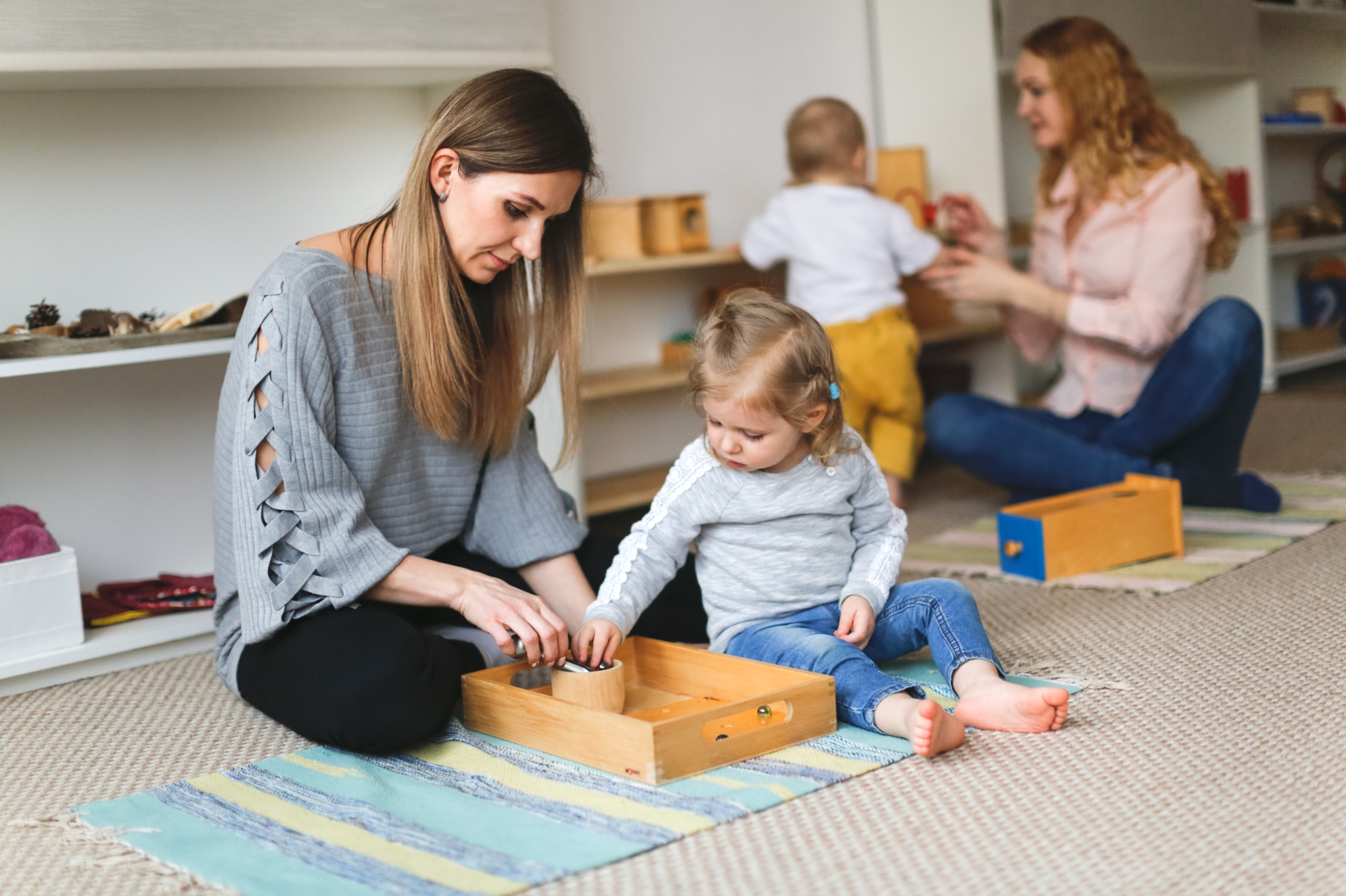 Mütter spielen im Kinderbereich mit ihren Babys.