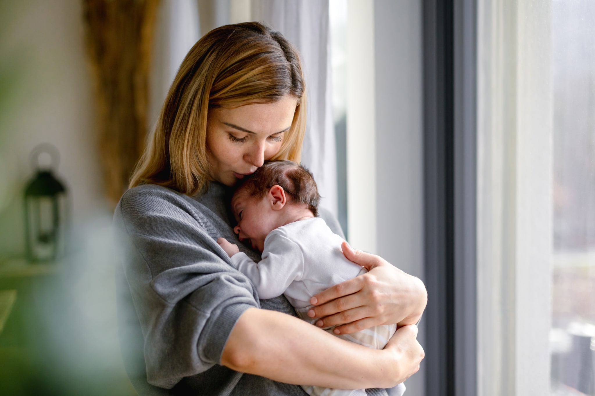 Mutter umarmt ihr neugeborenes Baby liebevoll